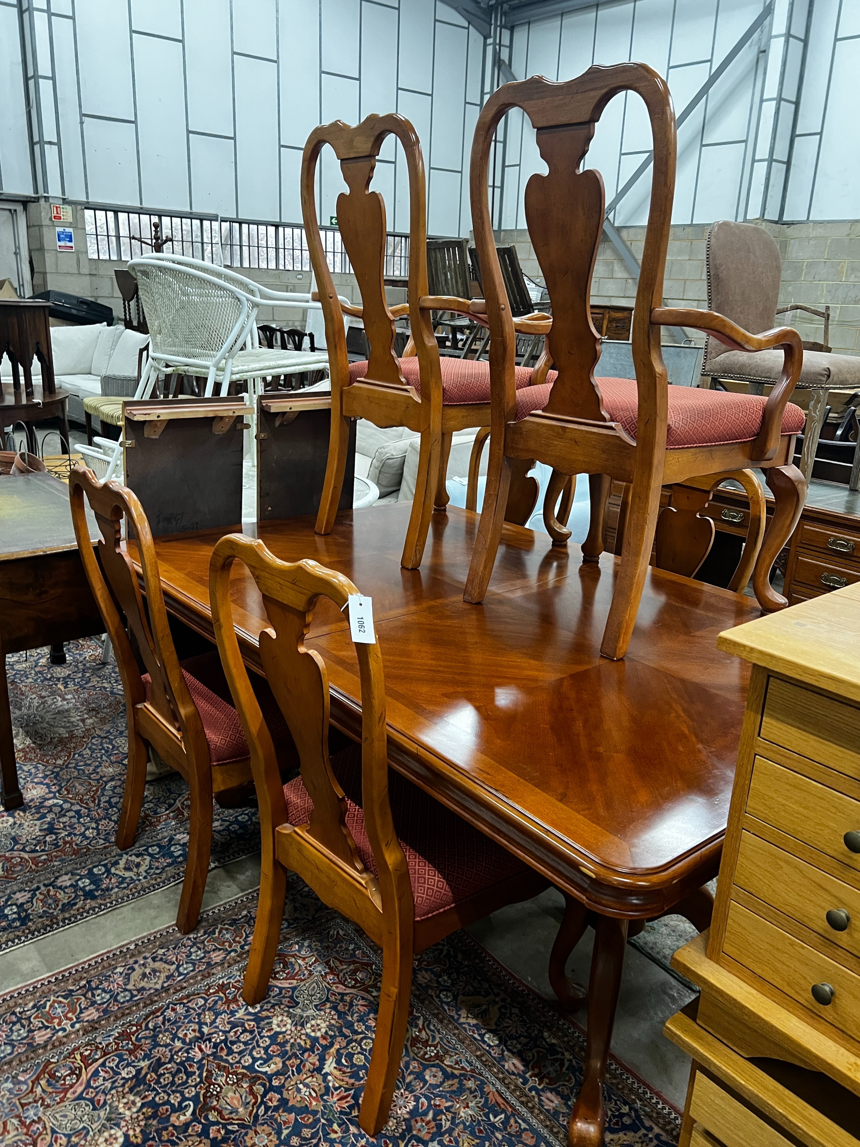 A reproduction Queen Anne style banded cherry twin pillar extending dining table, length 240cm extended (two spare leaves), depth 110cm, height 75cm and six chairs, two with arms